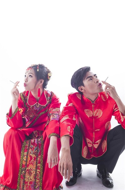 纯色背景中国喜庆婚纱照。欢乐的夫妇两