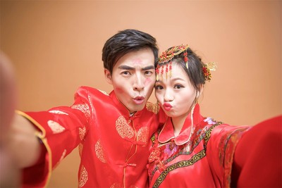 纯色背景中国喜庆婚纱照。欢乐的夫妇两_佳能