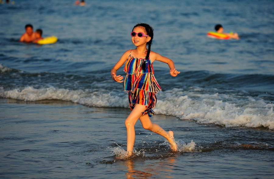 金沙滩戏水的小女孩