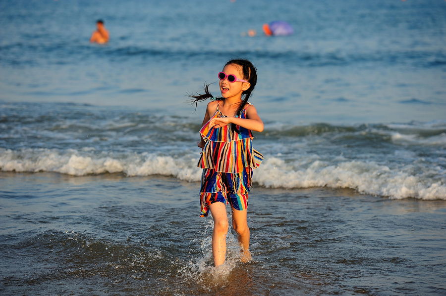 金沙滩戏水的小女孩