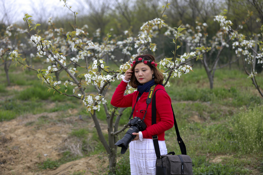 李花园中美女摄影师