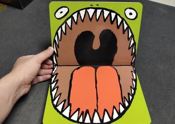 它不是一本书,它是一个怪物的大嘴,可以看到牙齿和小舌头.