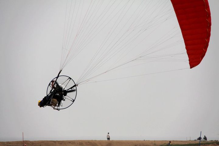 【海滩上的动力滑翔伞的比赛摄影图片】山东海