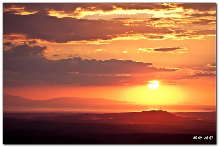 【从裕民县阿克乔湖草原眺望夕阳下的阿拉湖摄