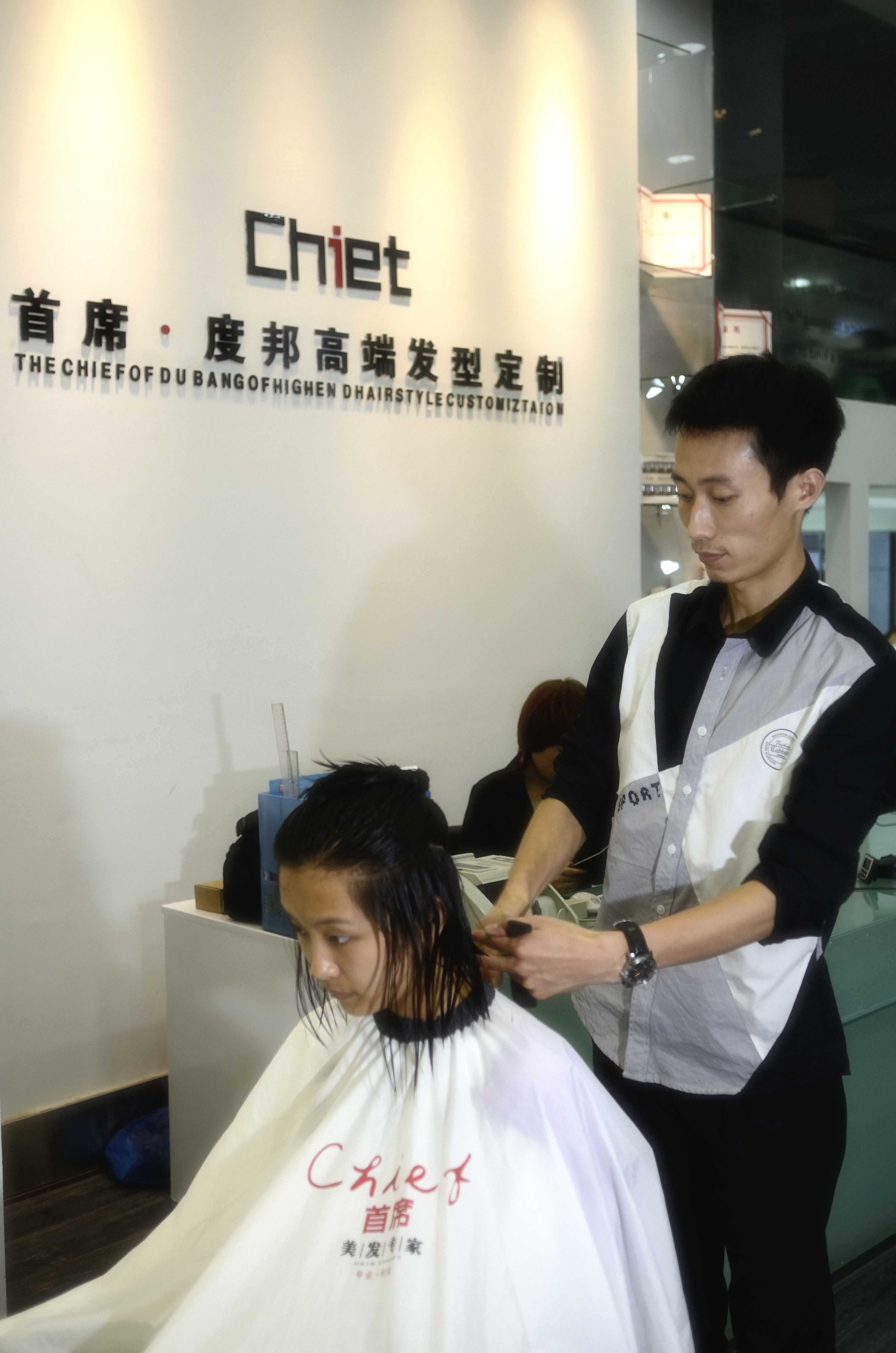 女理发师拿着吹风机站在理发店里-蓝牛仔影像-中国原创广告影像素材