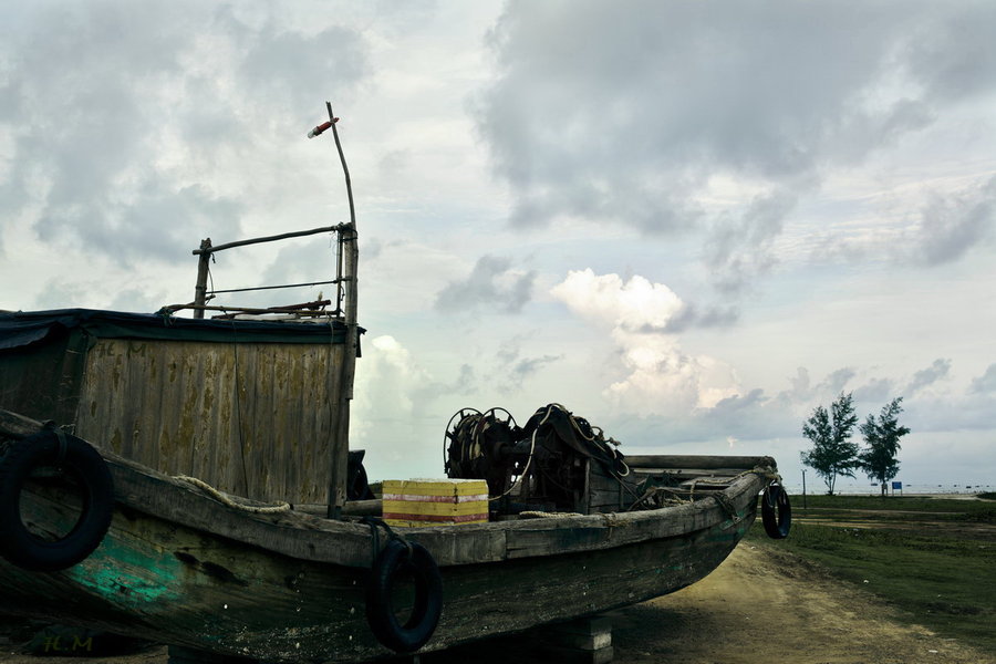 【一艘岸上的木船摄影图片】广西北海银滩风光